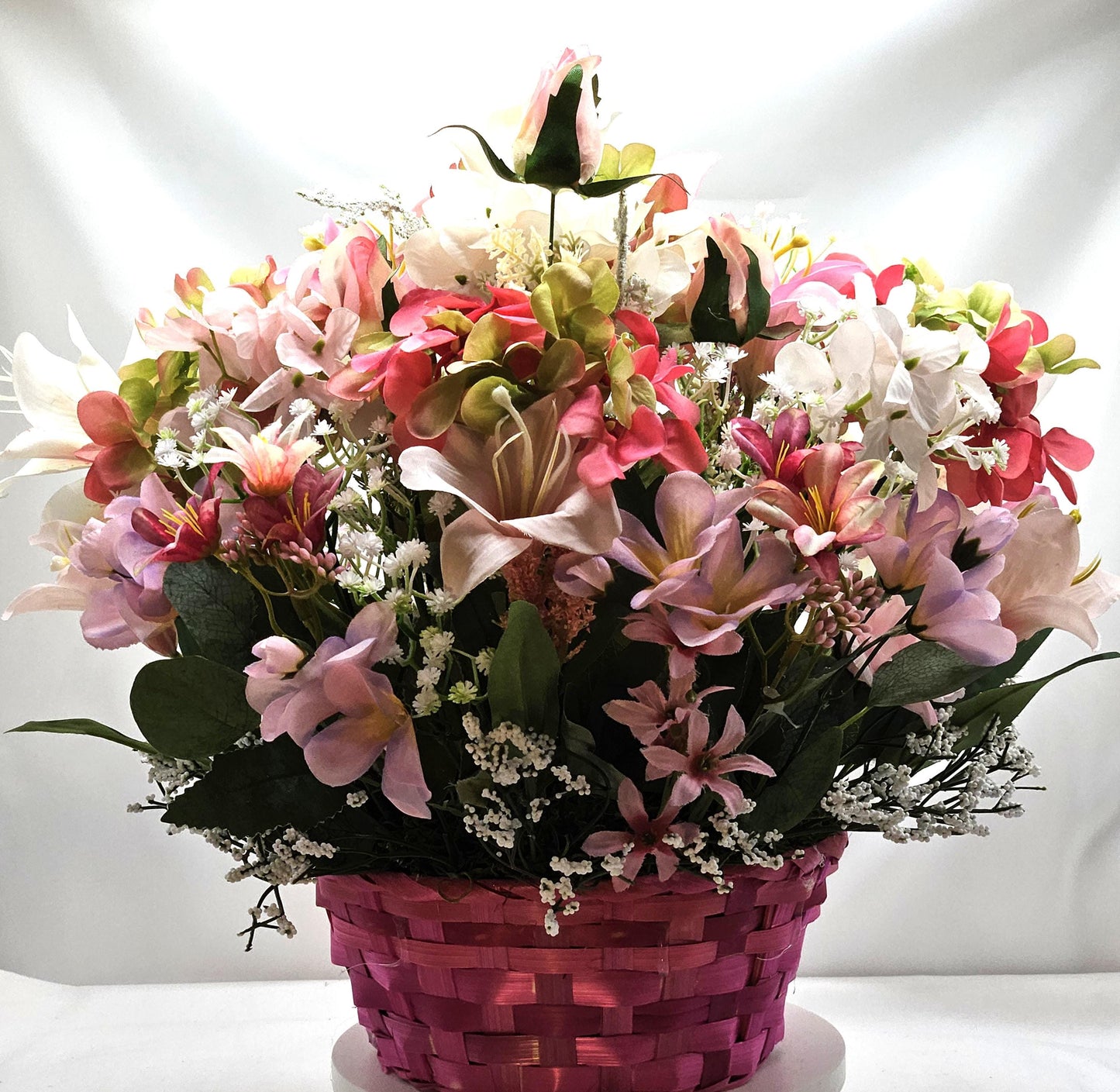 Bright Blue or Pink Easter Basket With Wooden Rabbit Accents in front of Vibrant Pin/White or Purple/White Lily Garden