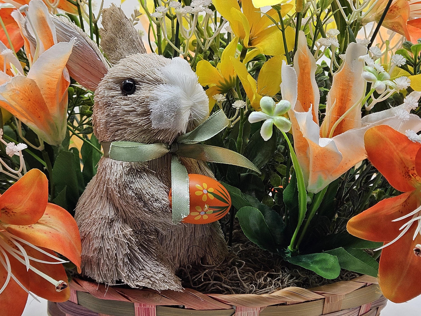 Rattan Easter Bunny in a Multi-colored Basket, Surrounded by Lush and Lovely Lilies, Greens, Baby's Breath,Orange and Yellow Hues