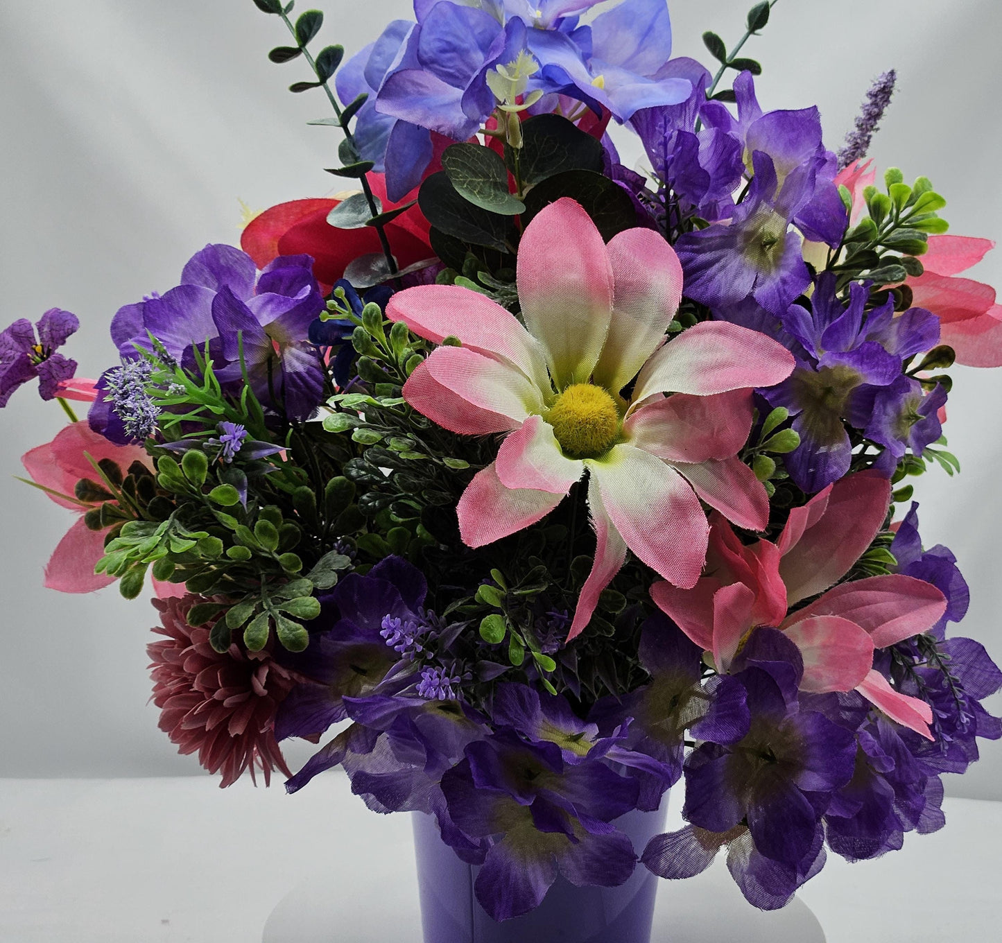 Charming Thinking Of You Bouquet set in a light purple container and accented with birds in a nest and/Atop Flowers/Pink/White/Blue/Greenery