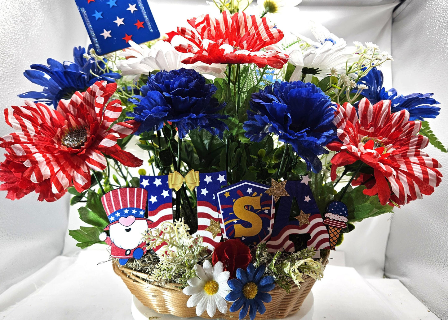 Gnome in the USA Patriotic Flower Arrangement, Oval Wicker Basket, Red White Blue Daisies, Sunflowers, Carnations