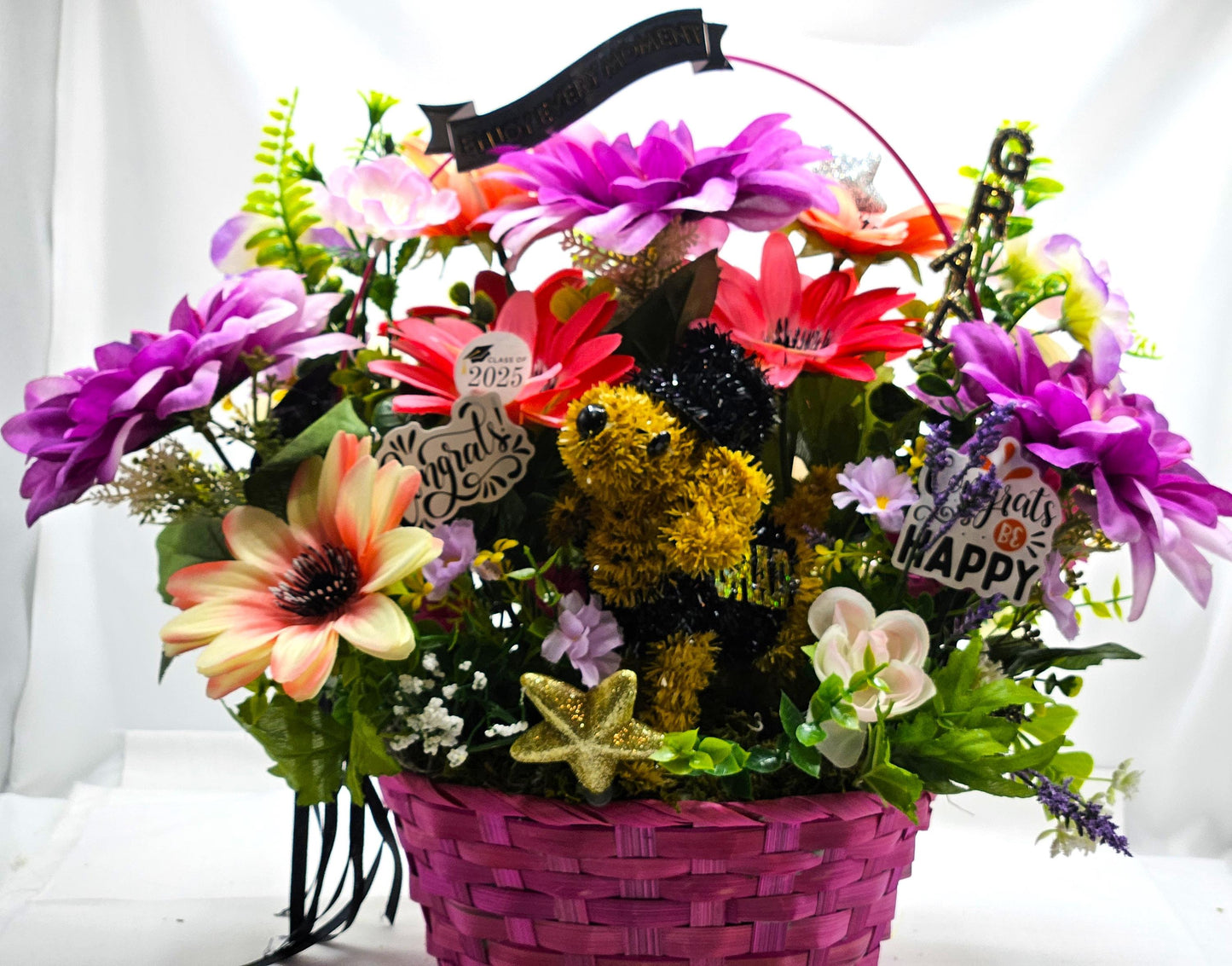 Whimsical Graduation Flower Arrangement in Pink Wicker Basket, Congrats and Enjoy Every Moment Signs with Pink/Purple Florals/Greenery