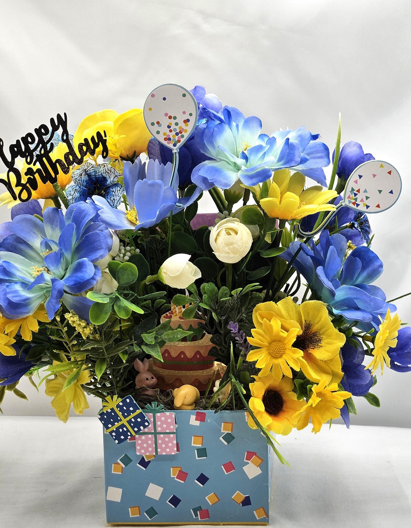 Birthday Flower Arrangement set in Blue Gift Box, Glittery BD Cake on the Lid, Lovely Blue/Yellow Blooms, Cute Bunnies, Baloons, Gifts