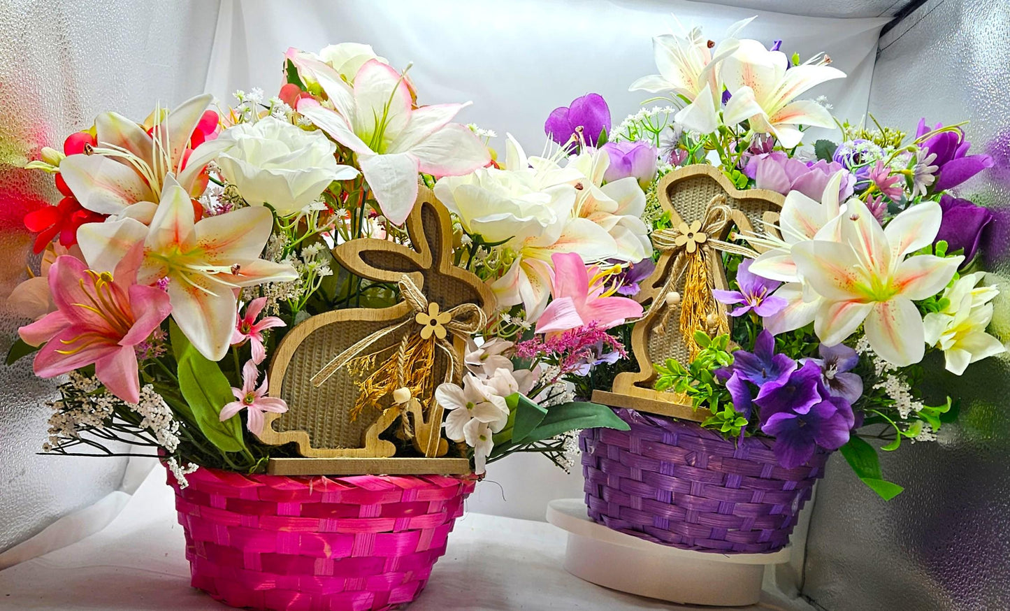 Bright Blue or Pink Easter Basket With Wooden Rabbit Accents in front of Vibrant Pin/White or Purple/White Lily Garden
