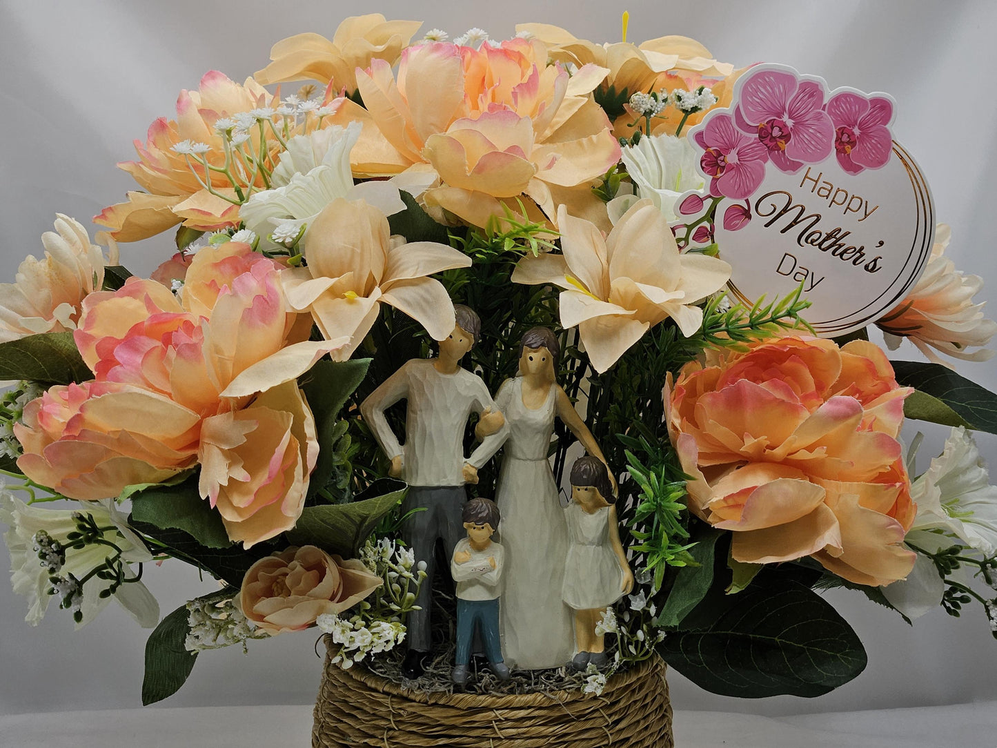 Family of Four Ceramic Figures Amidst Peach/White Flowers in Elegant Round Wicker Basket, Baby's Breath/Greenery/Mother's Day Sign