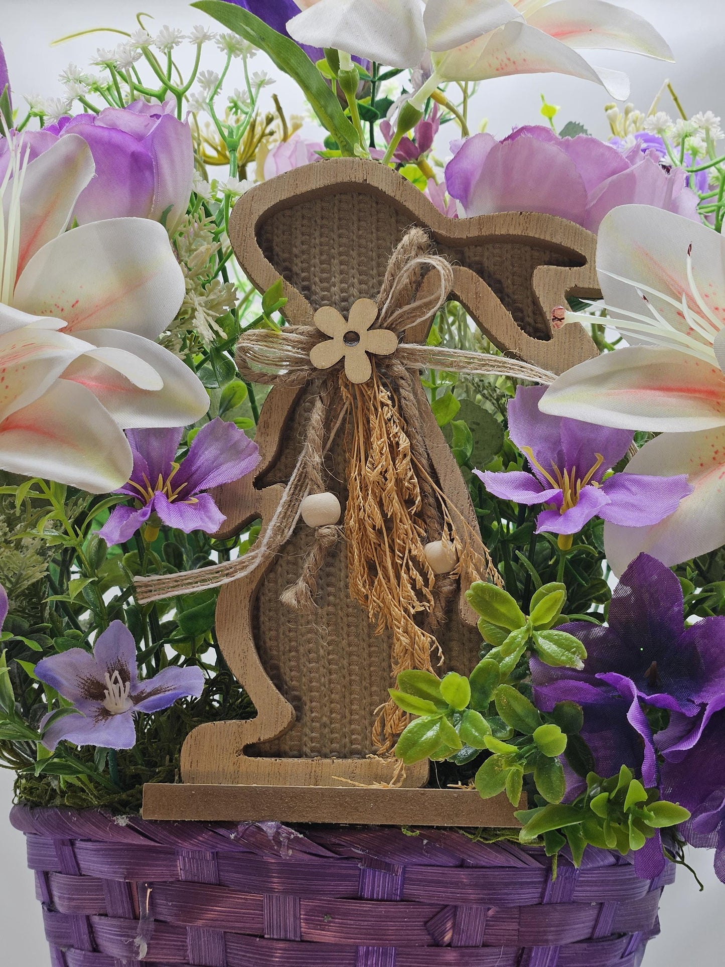 Bright Blue or Pink Easter Basket With Wooden Rabbit Accents in front of Vibrant Pin/White or Purple/White Lily Garden