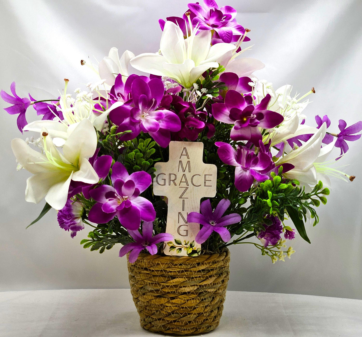 Amazing Grace Elegant Floral Arrangement Featuring a White Wooden Cross Nestled Amidst a Garden of White Lilies/Purple Orchids/wicker Basket