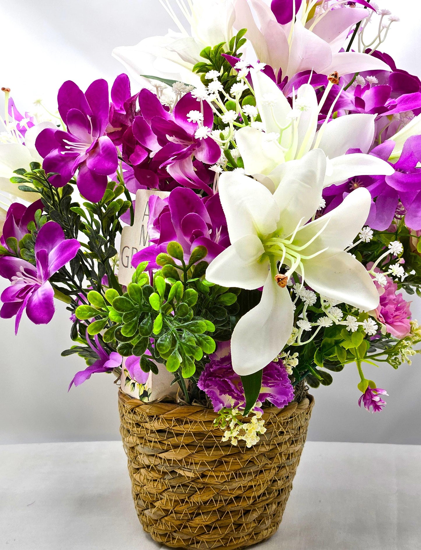Amazing Grace Elegant Floral Arrangement Featuring a White Wooden Cross Nestled Amidst a Garden of White Lilies/Purple Orchids/wicker Basket