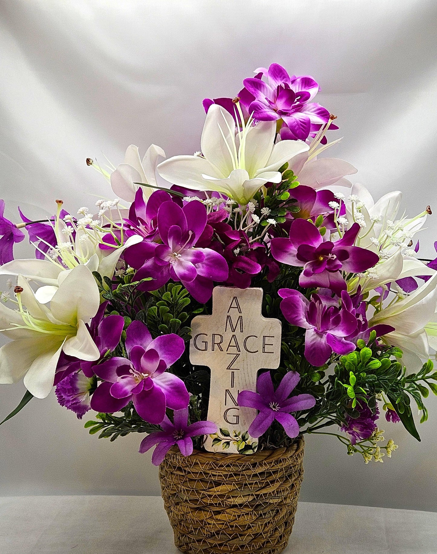 Amazing Grace Elegant Floral Arrangement Featuring a White Wooden Cross Nestled Amidst a Garden of White Lilies/Purple Orchids/wicker Basket