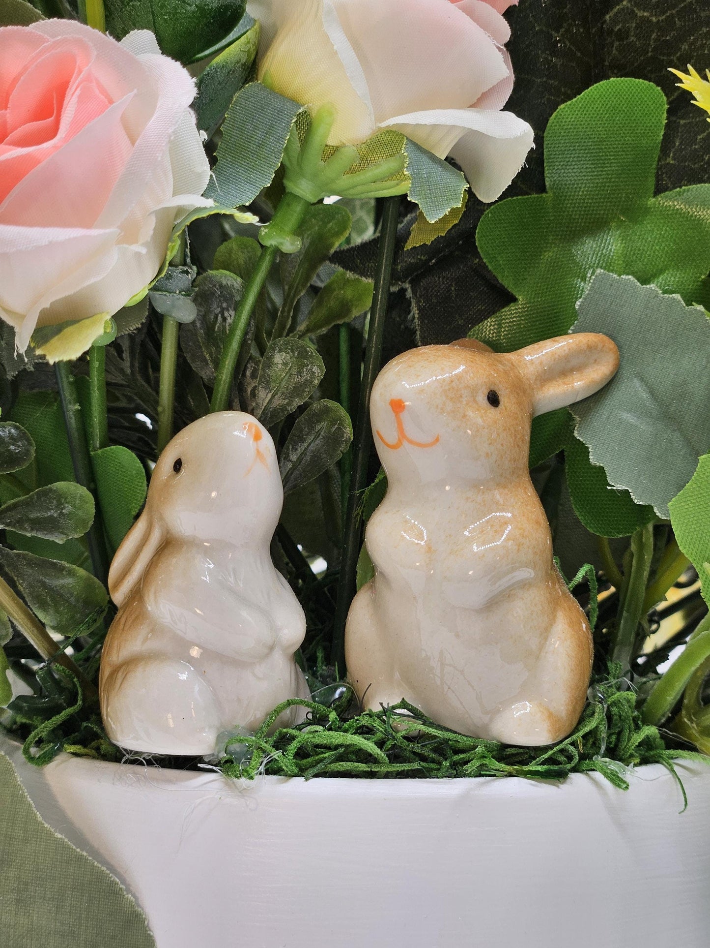 Ceramic Bunnies in a Pink/Peach/Yellow Flower Garden, Lush Greens and Baby's Breath, All Nestled in a Two Tone Ceramic Beige/White Vase
