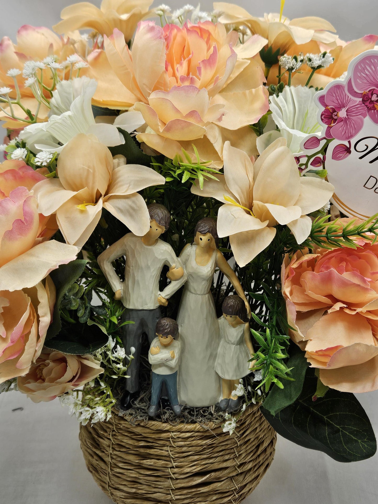 Family of Four Ceramic Figures Amidst Peach/White Flowers in Elegant Round Wicker Basket, Baby's Breath/Greenery/Mother's Day Sign