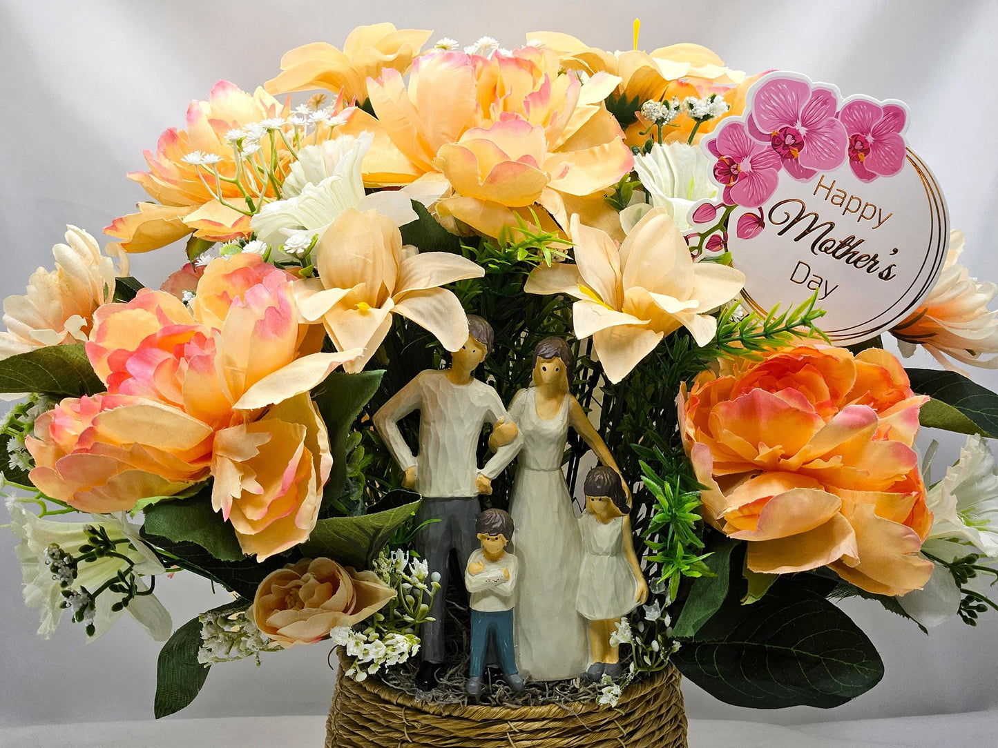Family of Four Ceramic Figures Amidst Peach/White Flowers in Elegant Round Wicker Basket, Baby's Breath/Greenery/Mother's Day Sign