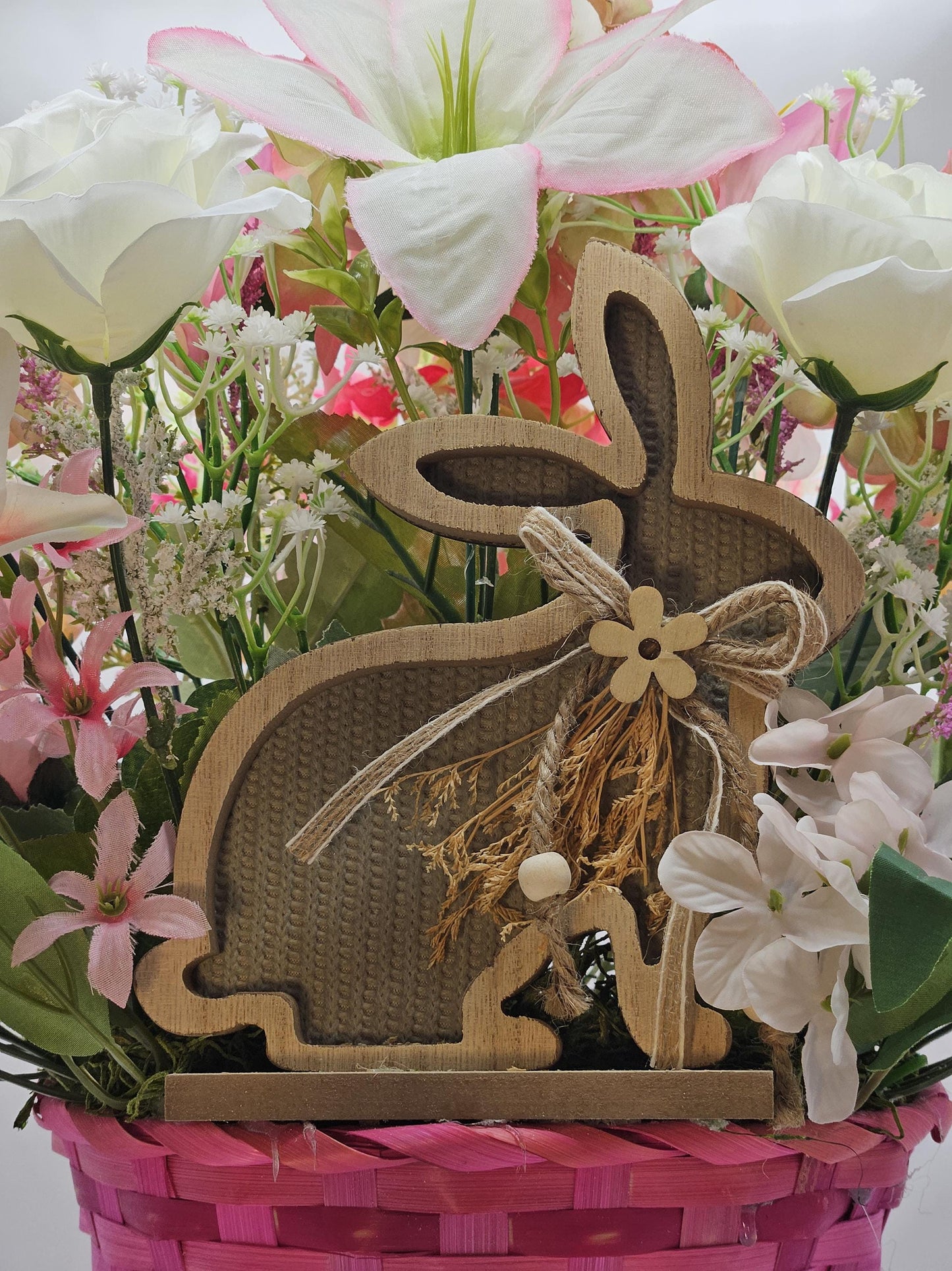 Bright Blue or Pink Easter Basket With Wooden Rabbit Accents in front of Vibrant Pin/White or Purple/White Lily Garden
