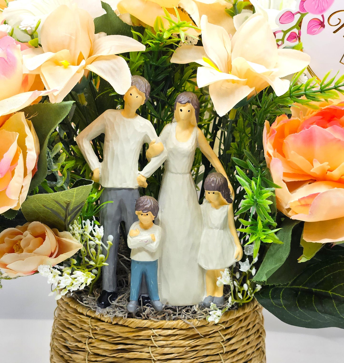 Family of Four Ceramic Figures Amidst Peach/White Flowers in Elegant Round Wicker Basket, Baby's Breath/Greenery/Mother's Day Sign