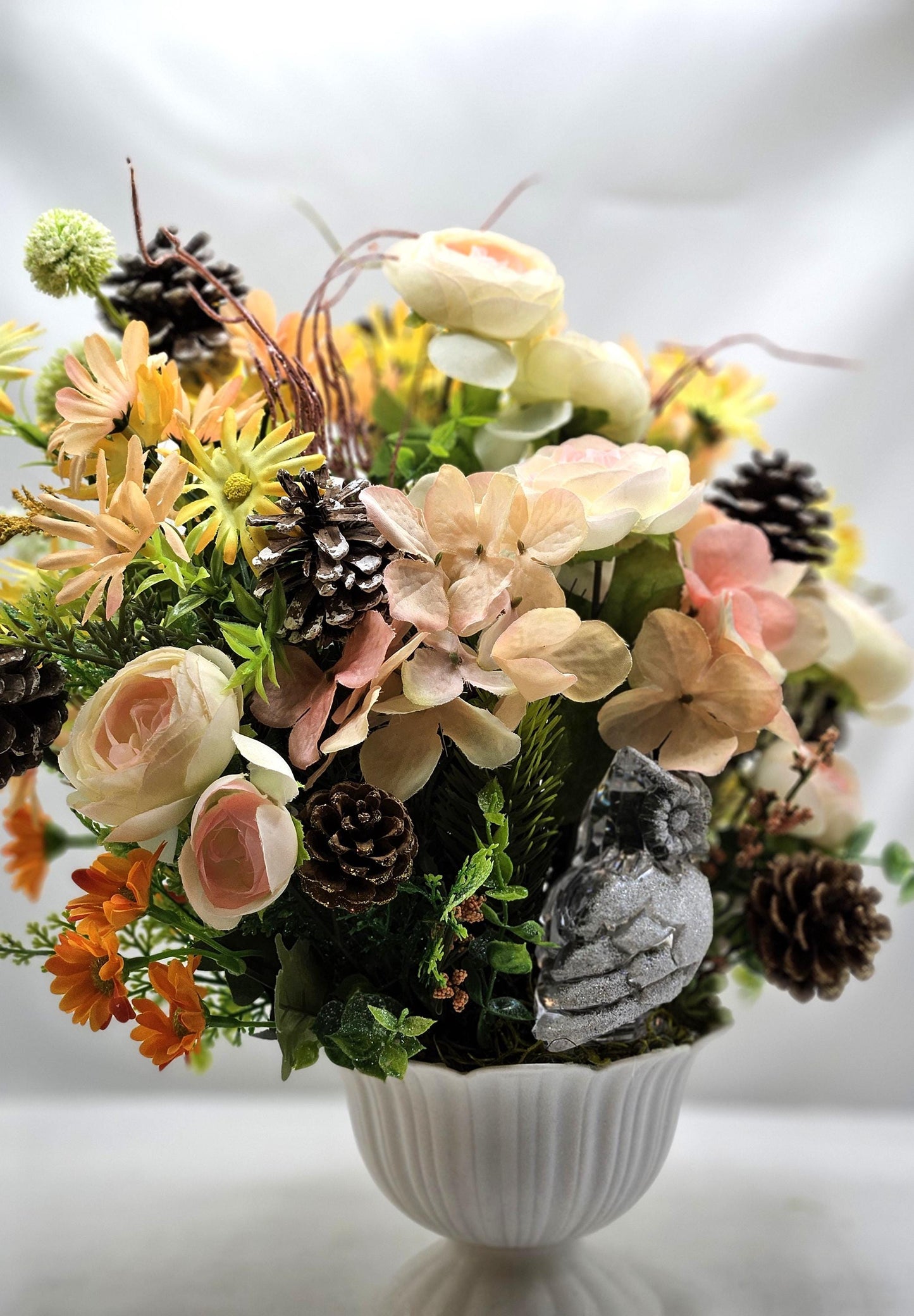 Striking Floral Centerpiece Featuring a Stunning Crystal-Look Majestic Owl Amidst a Garden of Multi-Colored WildflowersGreenery/PineCones