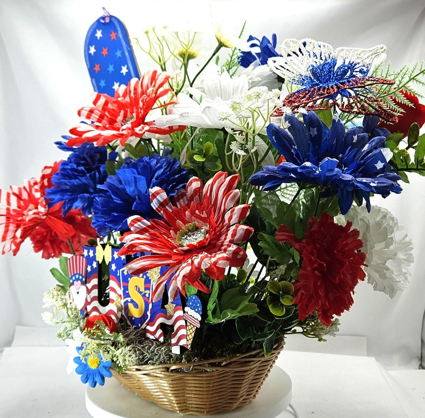 Gnome in the USA Patriotic Flower Arrangement, Oval Wicker Basket, Red White Blue Daisies, Sunflowers, Carnations