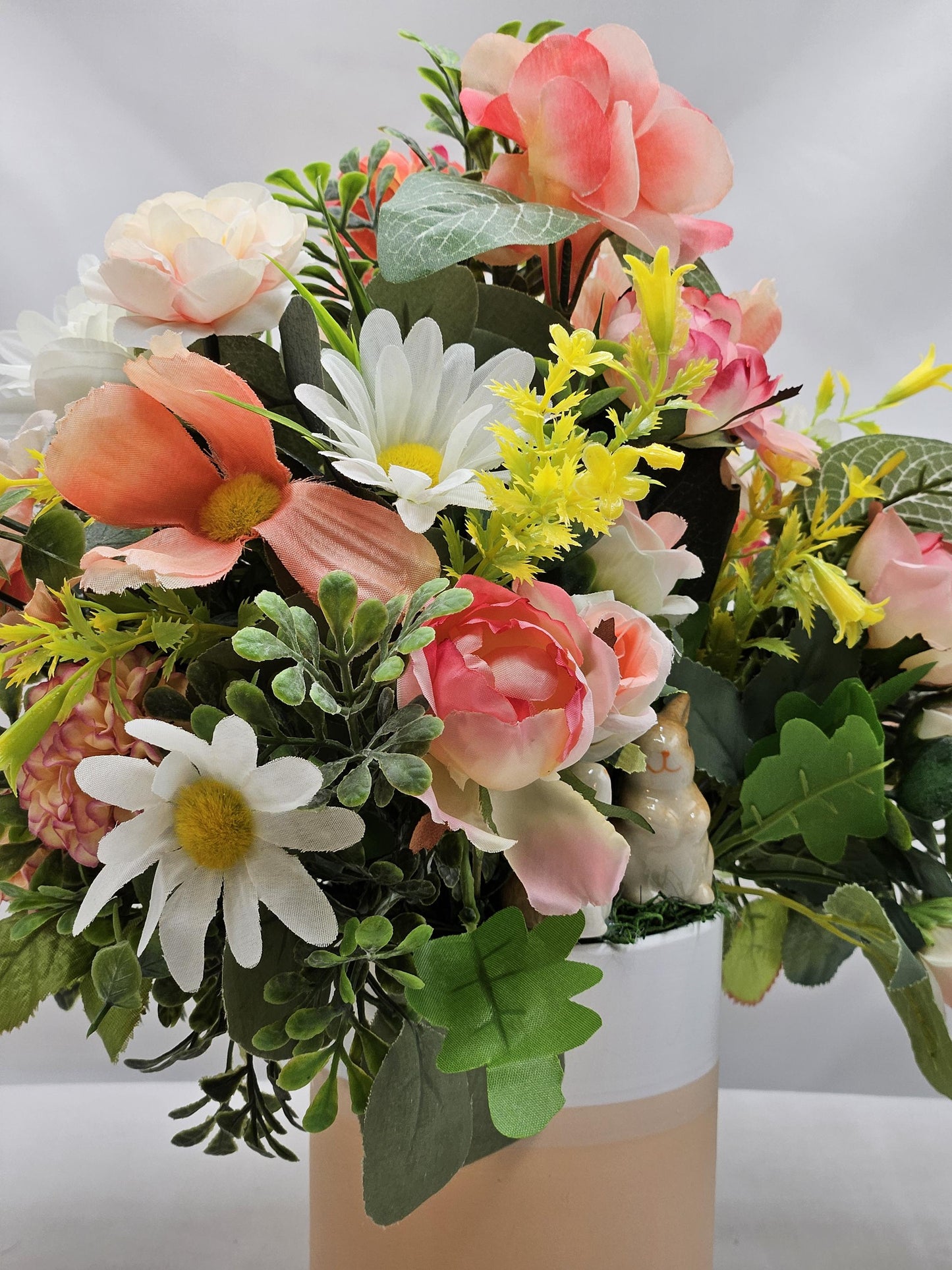 Ceramic Bunnies in a Pink/Peach/Yellow Flower Garden, Lush Greens and Baby's Breath, All Nestled in a Two Tone Ceramic Beige/White Vase
