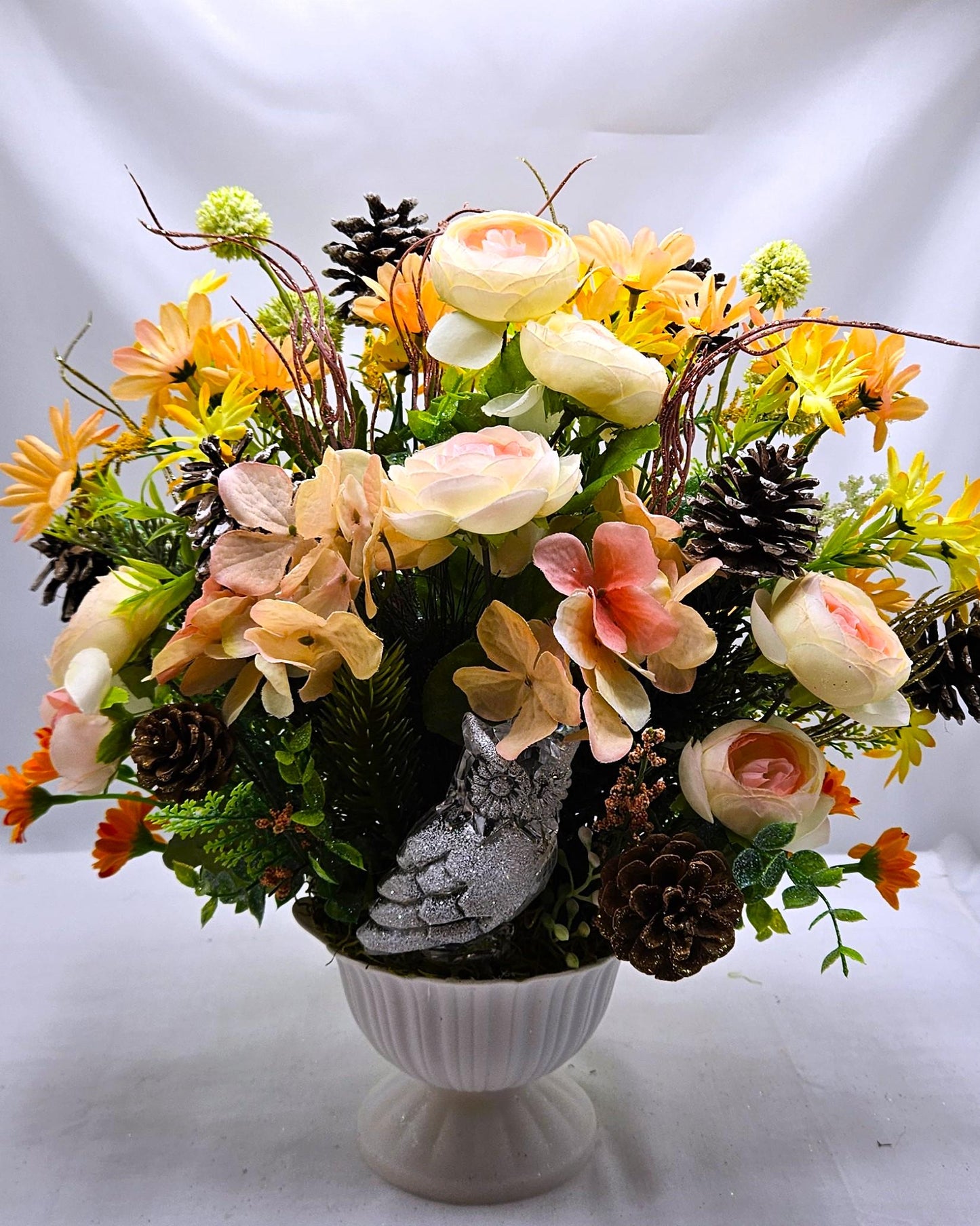 Striking Floral Centerpiece Featuring a Stunning Crystal-Look Majestic Owl Amidst a Garden of Multi-Colored WildflowersGreenery/PineCones
