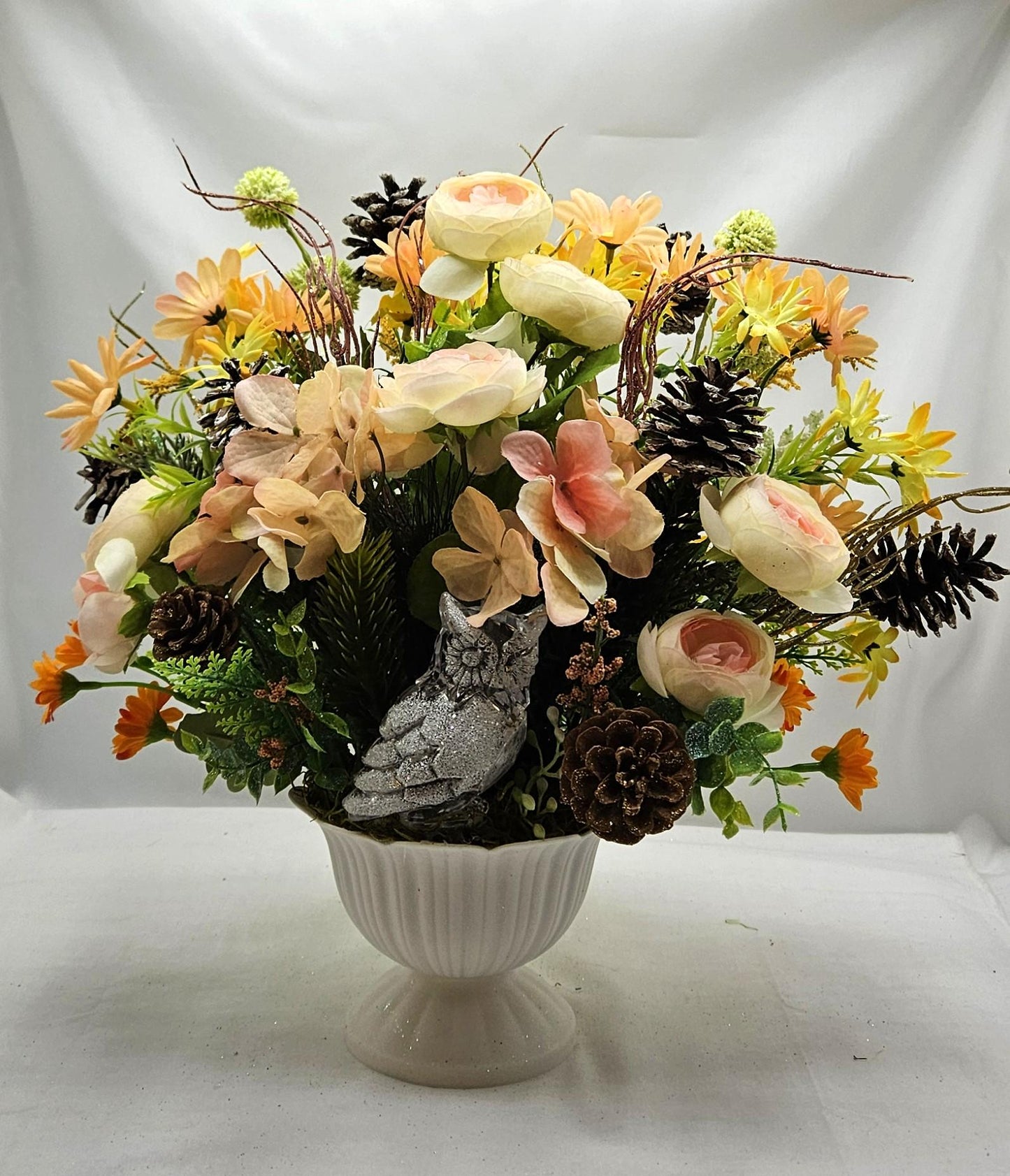 Striking Floral Centerpiece Featuring a Stunning Crystal-Look Majestic Owl Amidst a Garden of Multi-Colored WildflowersGreenery/PineCones