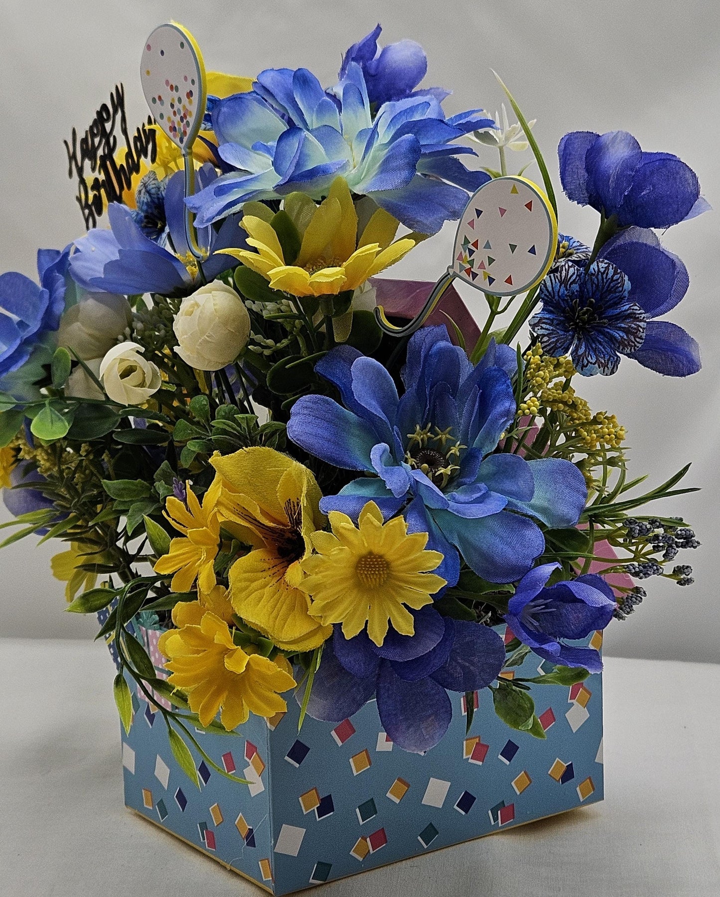 Birthday Flower Arrangement set in Blue Gift Box, Glittery BD Cake on the Lid, Lovely Blue/Yellow Blooms, Cute Bunnies, Baloons, Gifts