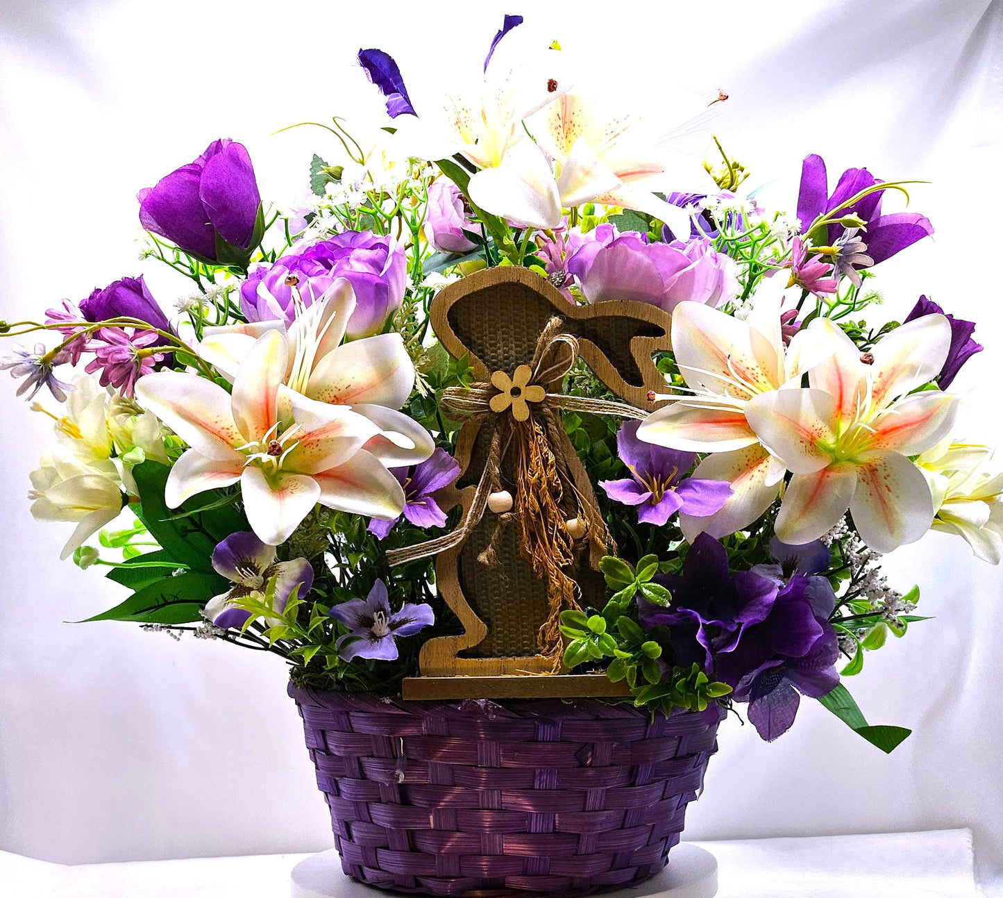 Bright Blue or Pink Easter Basket With Wooden Rabbit Accents in front of Vibrant Pin/White or Purple/White Lily Garden