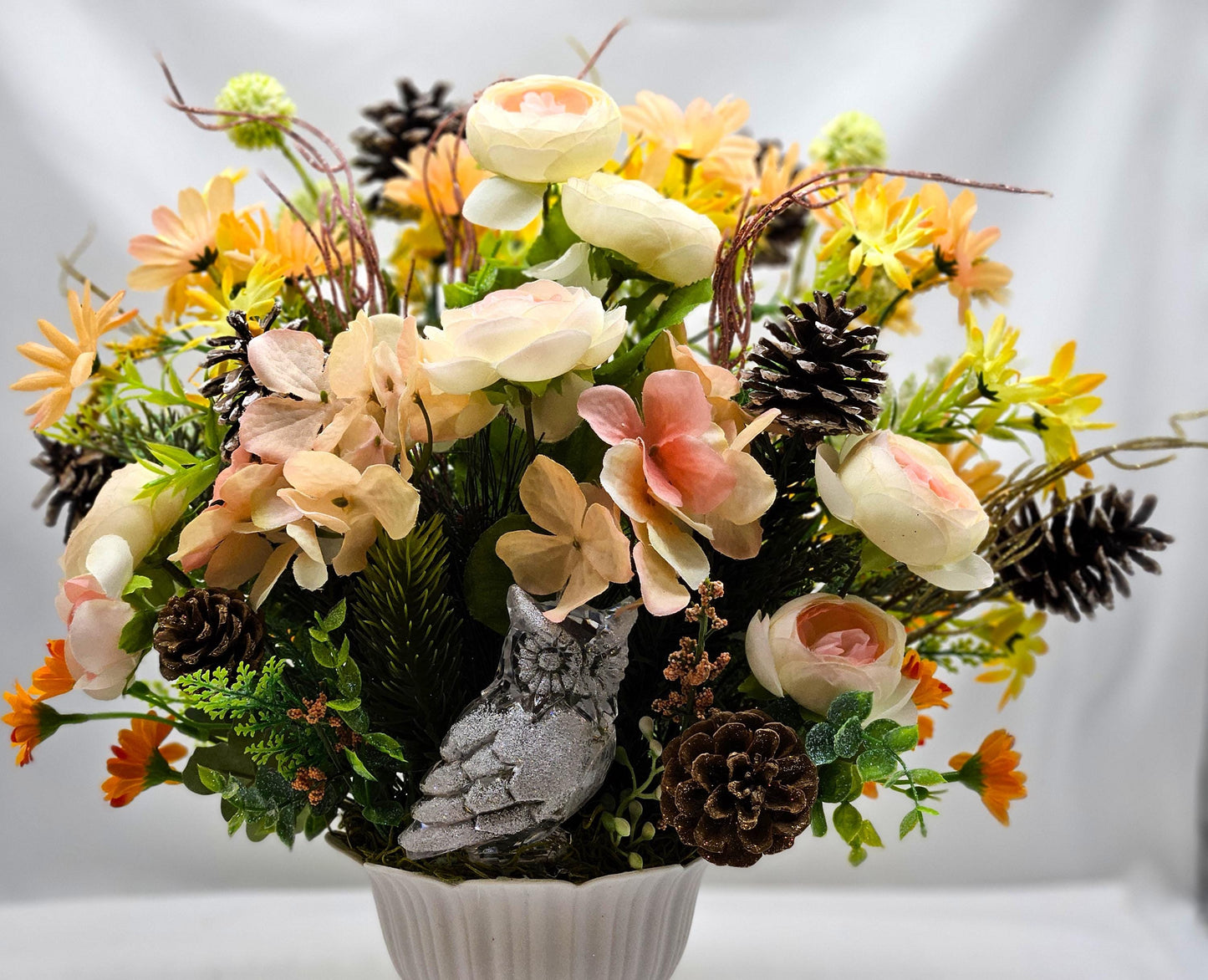 Striking Floral Centerpiece Featuring a Stunning Crystal-Look Majestic Owl Amidst a Garden of Multi-Colored WildflowersGreenery/PineCones