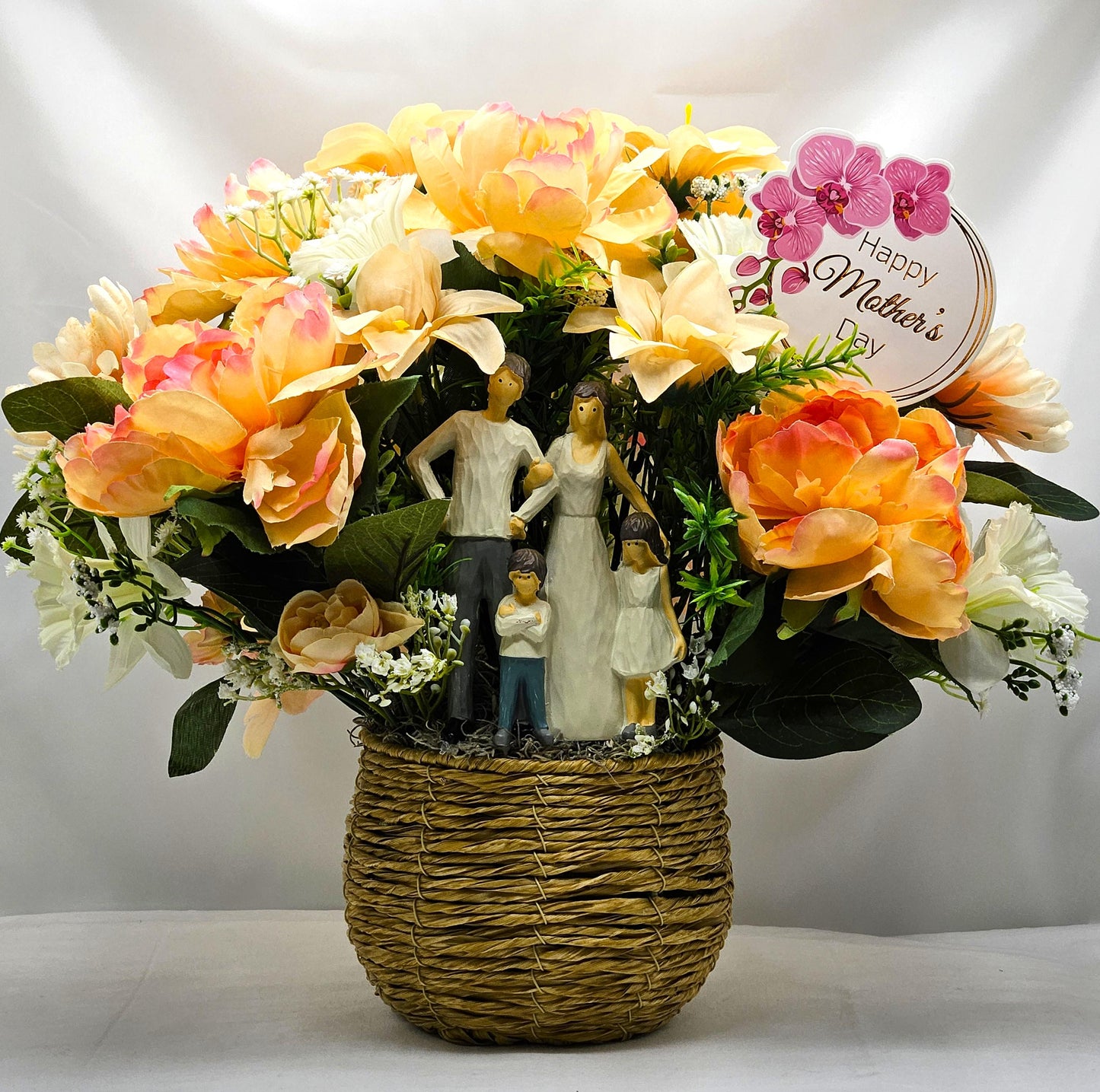 Family of Four Ceramic Figures Amidst Peach/White Flowers in Elegant Round Wicker Basket, Baby's Breath/Greenery/Mother's Day Sign