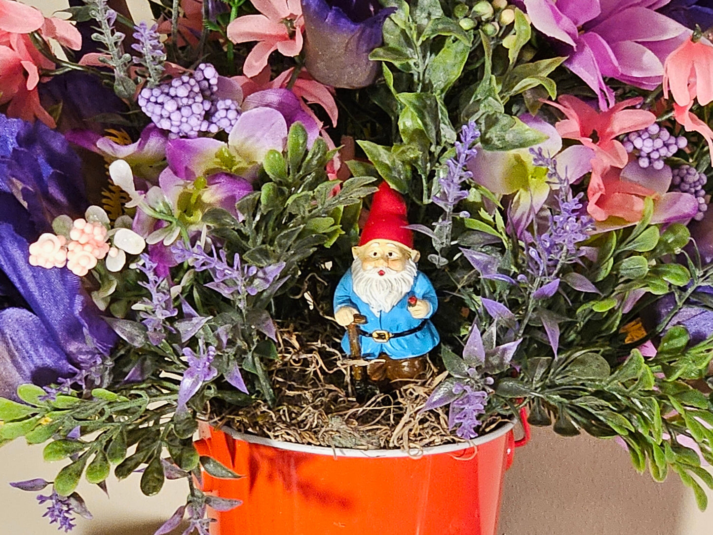 Artificial Floral Arrangement in Round Red Bucket with Gnome
