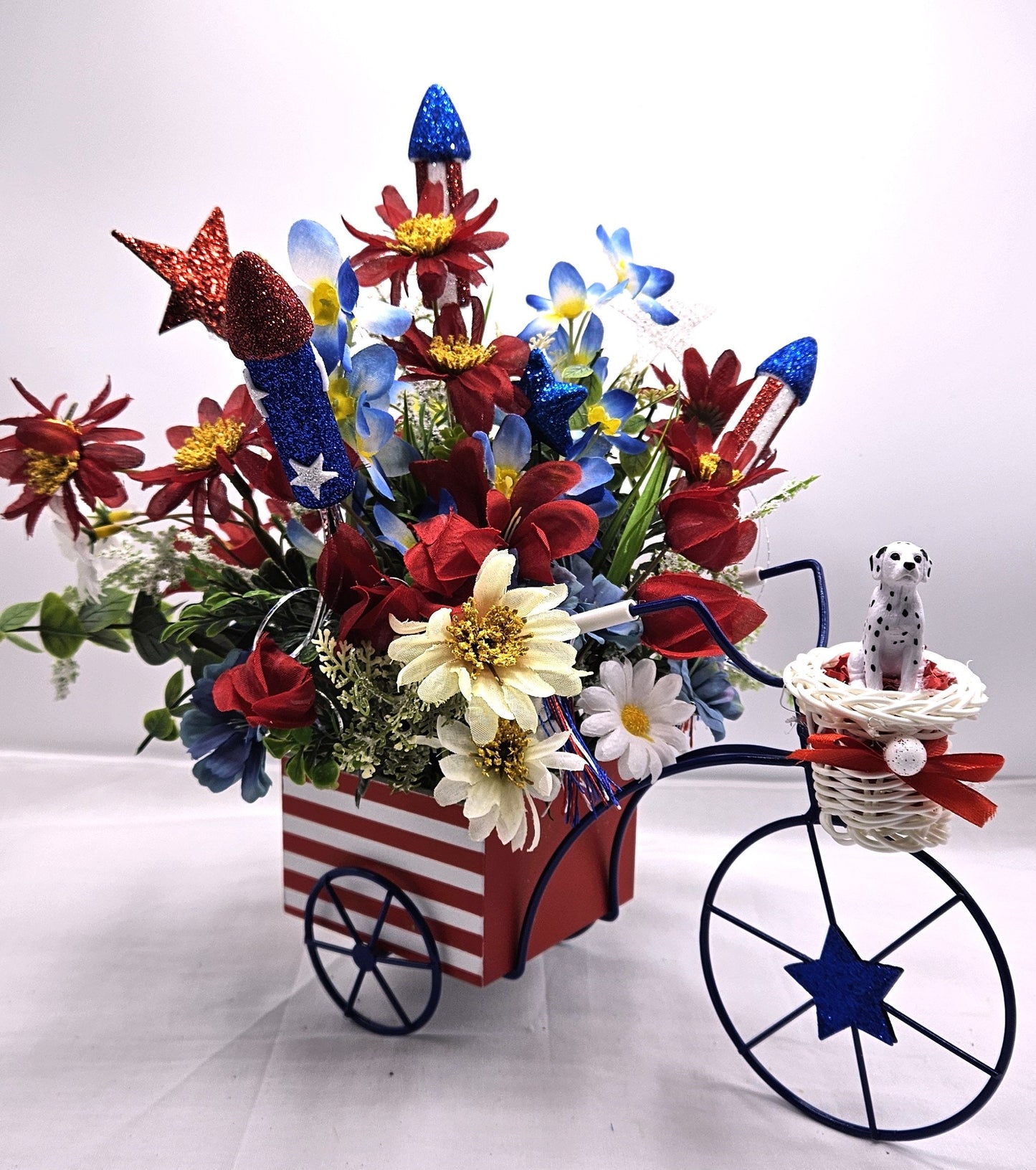 Americana Flower Arrangement Set in Bicycle Container with Red/White/Blue Flowers, sparkly Firecrackers and Stars, Basket with Dalmatian Dog