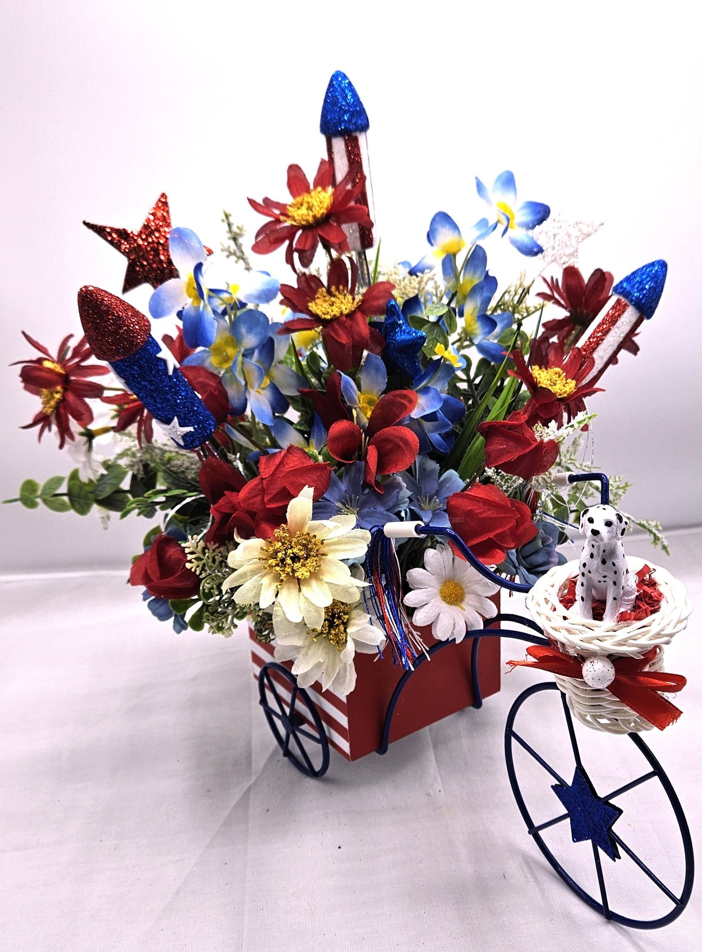 Americana Flower Arrangement Set in Bicycle Container with Red/White/Blue Flowers, sparkly Firecrackers and Stars, Basket with Dalmatian Dog