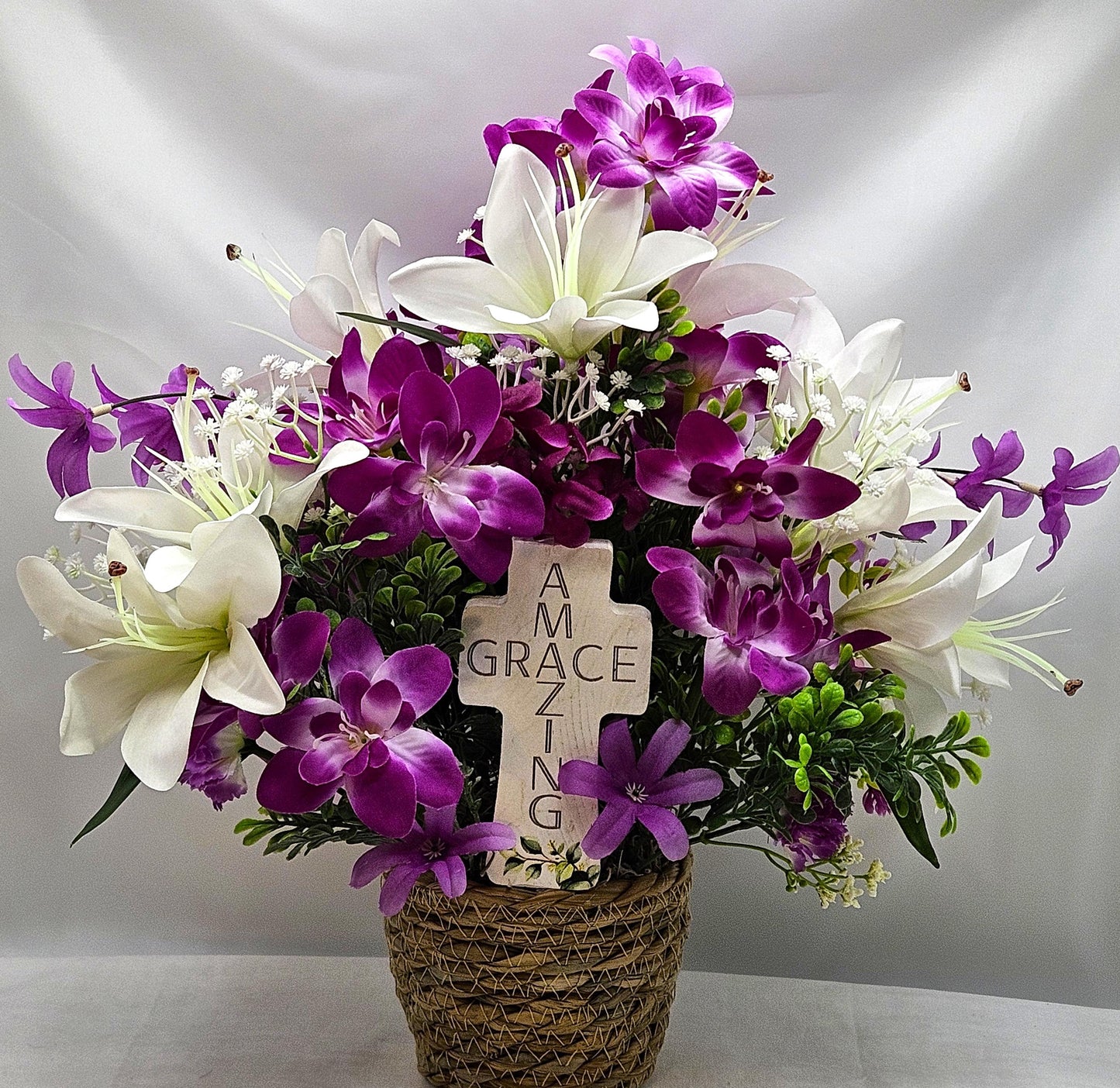 Amazing Grace Elegant Floral Arrangement Featuring a White Wooden Cross Nestled Amidst a Garden of White Lilies/Purple Orchids/wicker Basket