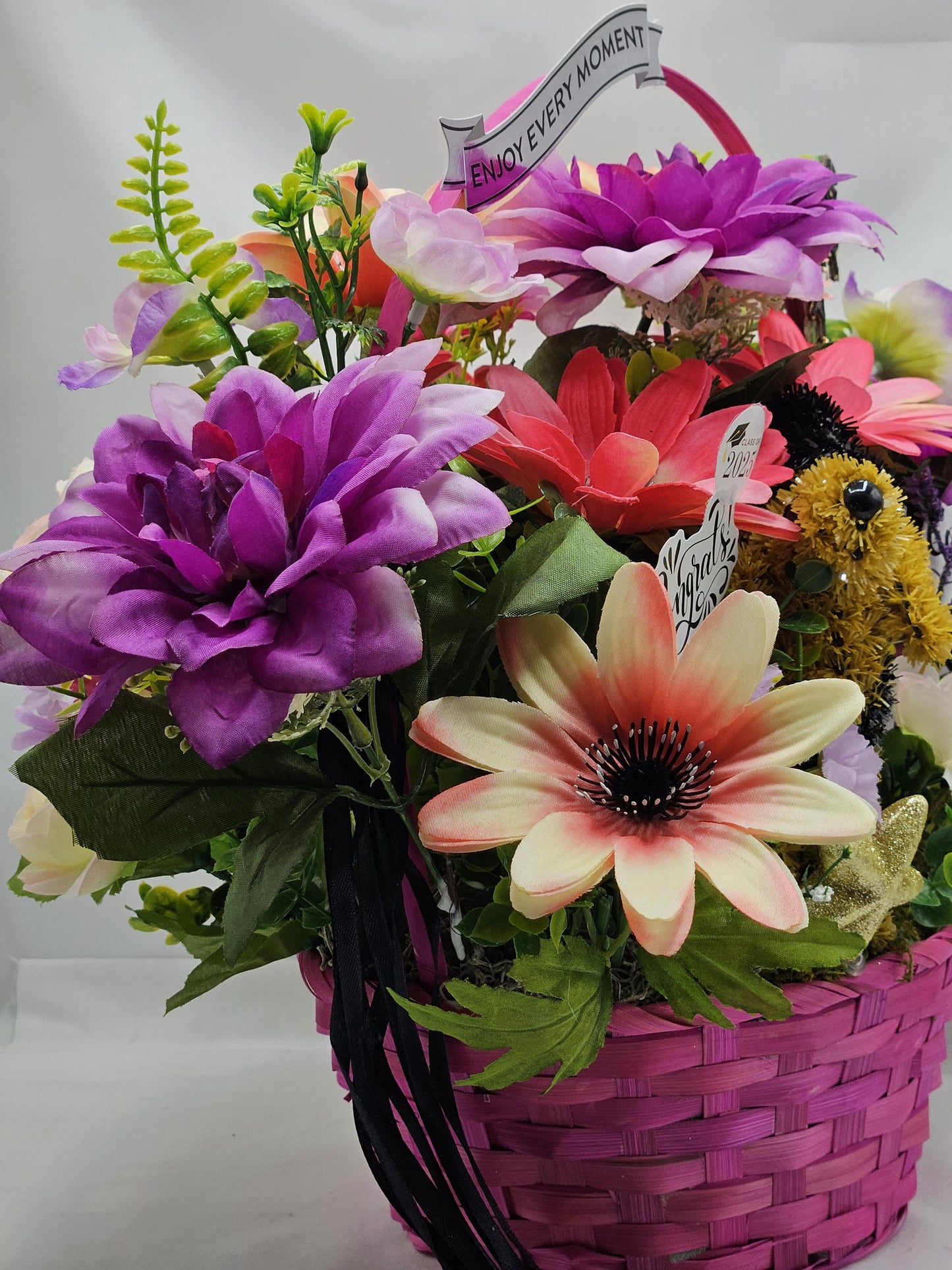 Whimsical Graduation Flower Arrangement in Pink Wicker Basket, Congrats and Enjoy Every Moment Signs with Pink/Purple Florals/Greenery