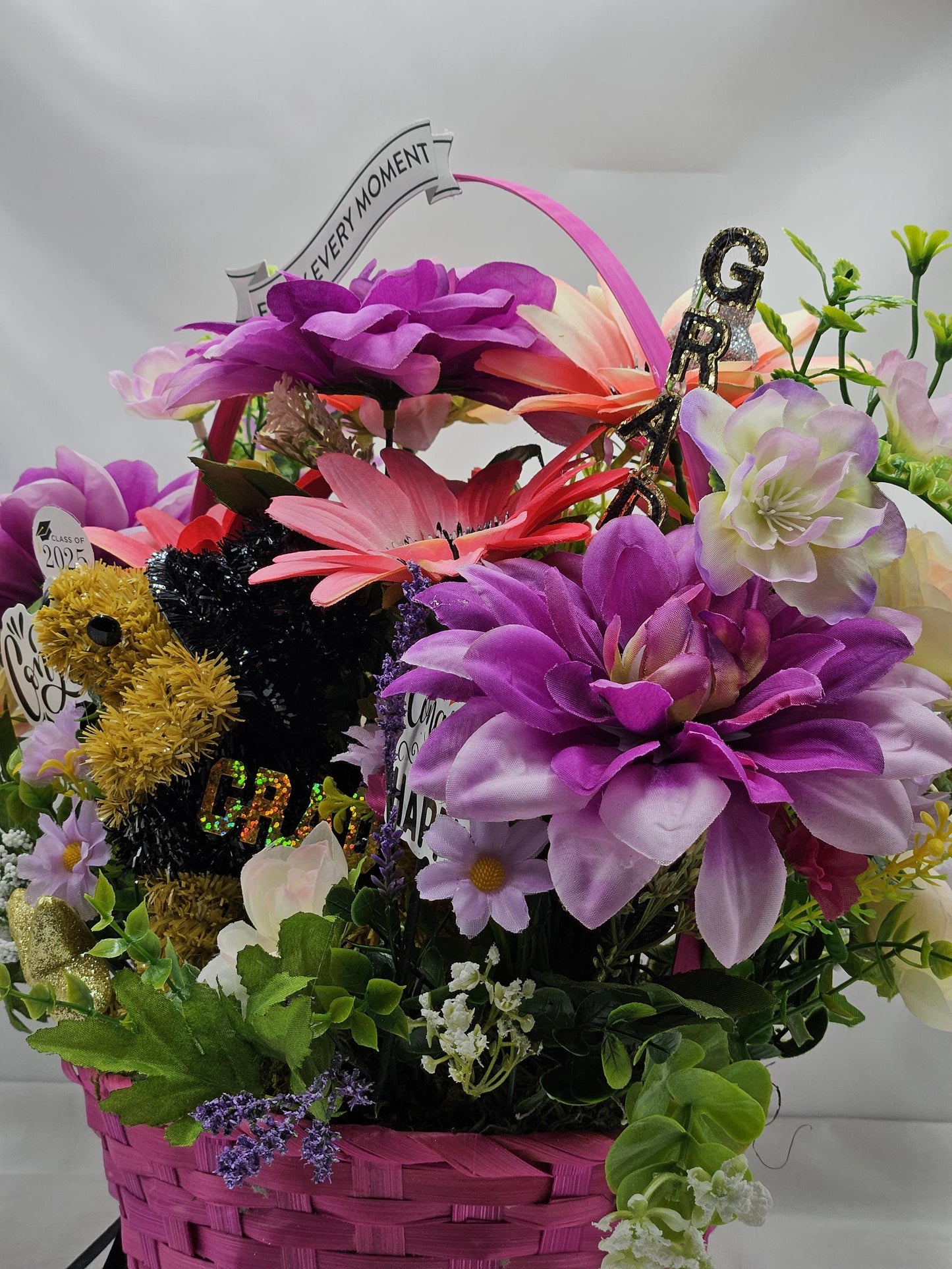 Whimsical Graduation Flower Arrangement in Pink Wicker Basket, Congrats and Enjoy Every Moment Signs with Pink/Purple Florals/Greenery